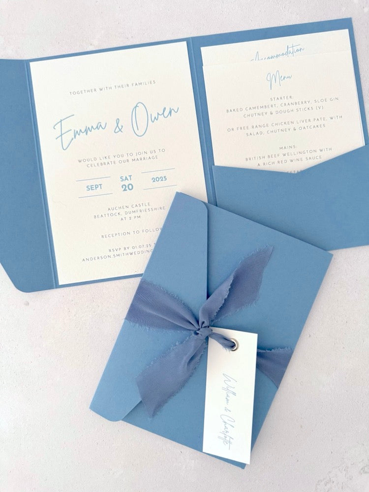 dusky cornflower blue emma pocketfold wedding invite with 2 inserts for menu and accommodation details, with silk ribbon and guest name tag