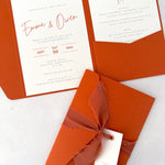 rust terracotta orange emma pocketfold wedding invite with 2 inserts for menu and accommodation details, with silk ribbon and guest name tag