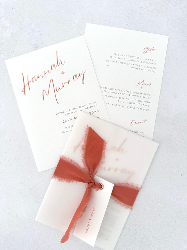 Hannah wedding invitation with tied silk ribbon and transparent vellum jacket. Guest name tag with metal eyelet.  Insert card for wedding info and menu options.