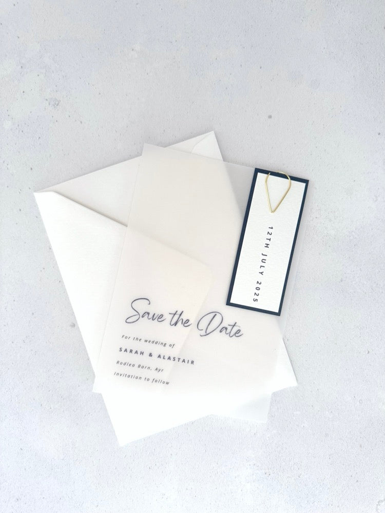 transparent vellum save the date card with navy date tag and gold teardrop paperclip