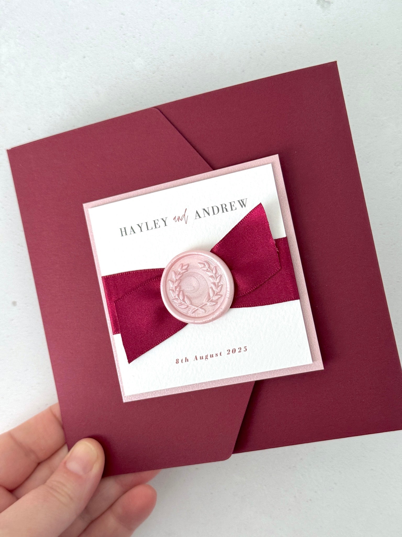 Burgundy red Ailsa pocket wedding invitation with satin ribbon and pink wax seal