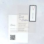 transparent vellum wedding invite with navy name tag and teardrop paperclip and details card with QR code