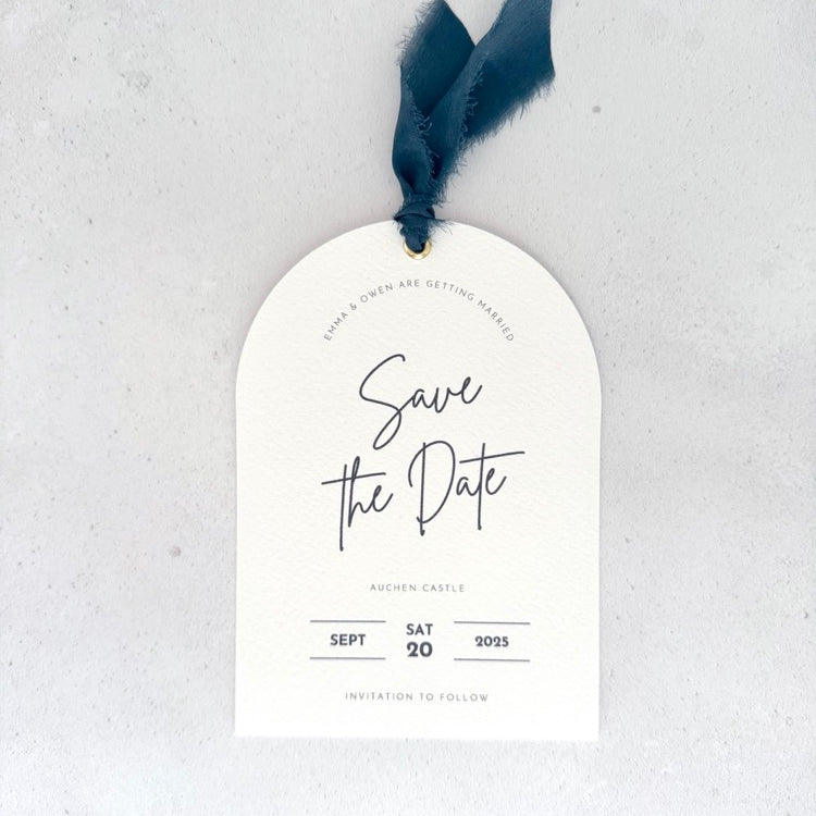 Textured white arched shaped save the date card with navy ribbon and  metal eyelet by handmade by zara