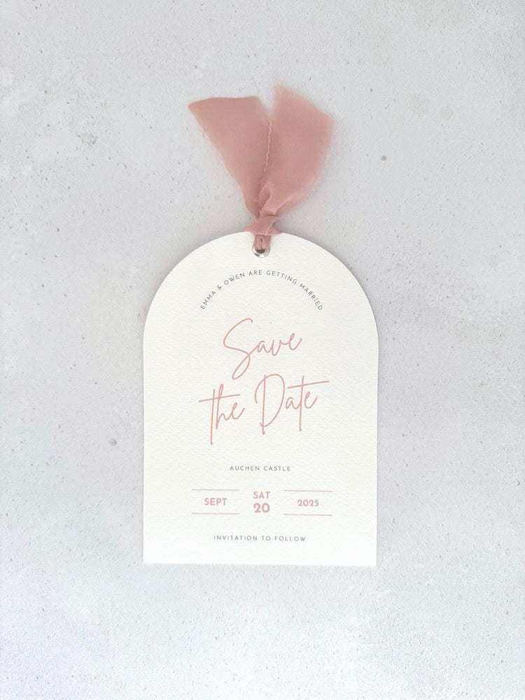 Textured white arched shaped save the date card with blush pink ribbon and  metal eyelet Handmade by Zara Dumfries