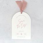 Textured white arched shaped save the date card with blush pink ribbon and  metal eyelet Handmade by Zara Dumfries