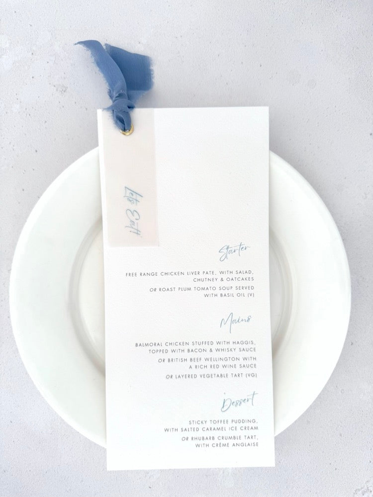 Handmade wedding day menu with dusky cornflower blue silk ribbon, vellum tag, and golf metal eyelet