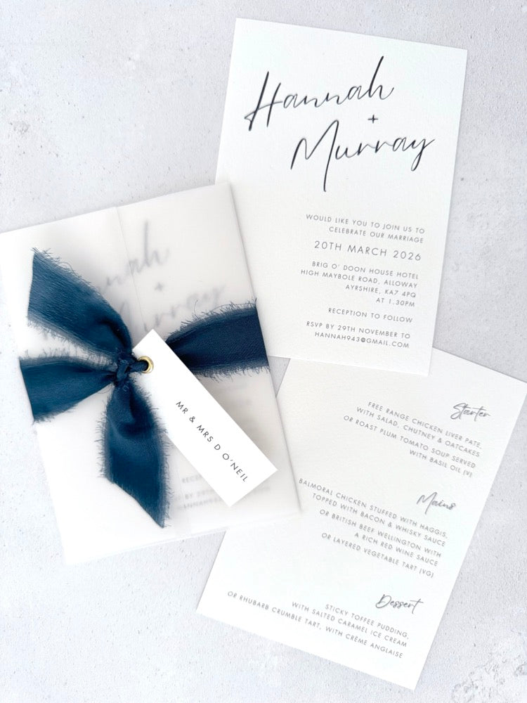 Navy Hannah vellum wrap wedding invite with tied silk ribbon and guest name tag. Insert card for wedding info and menu options. Brig O'Doon