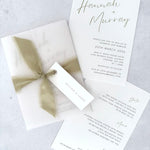 Sage green Hannah wedding invitation with tied silk ribbon and transparent vellum jacket. Guest name tag with metal eyelet.  Insert card for wedding info and menu options. 