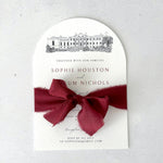 Finishing touch of silk burgundy ribbon on arch shaped venue illustration wedding invite