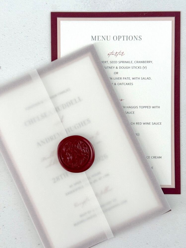 Burgundy wedding invite with transparent vellum paper wrap and wax seal