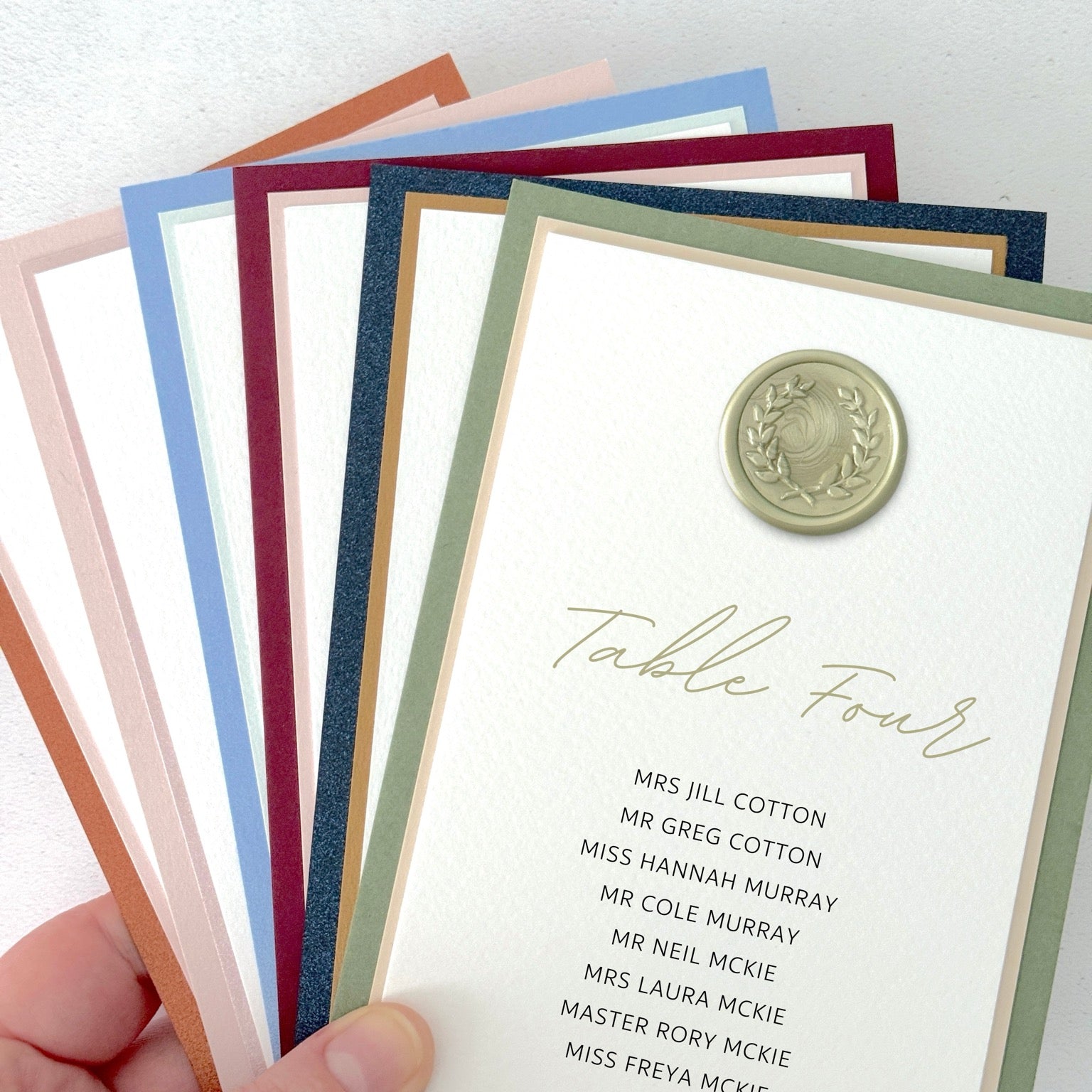 Sage green wax seal Jeni individual table plan card on the day wedding stationery