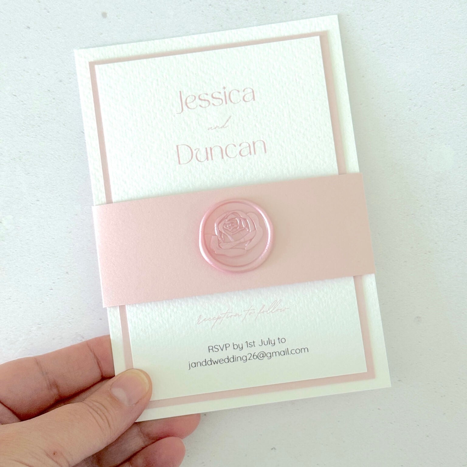 Pink handmade wedding invite with belly band and rose wax seal