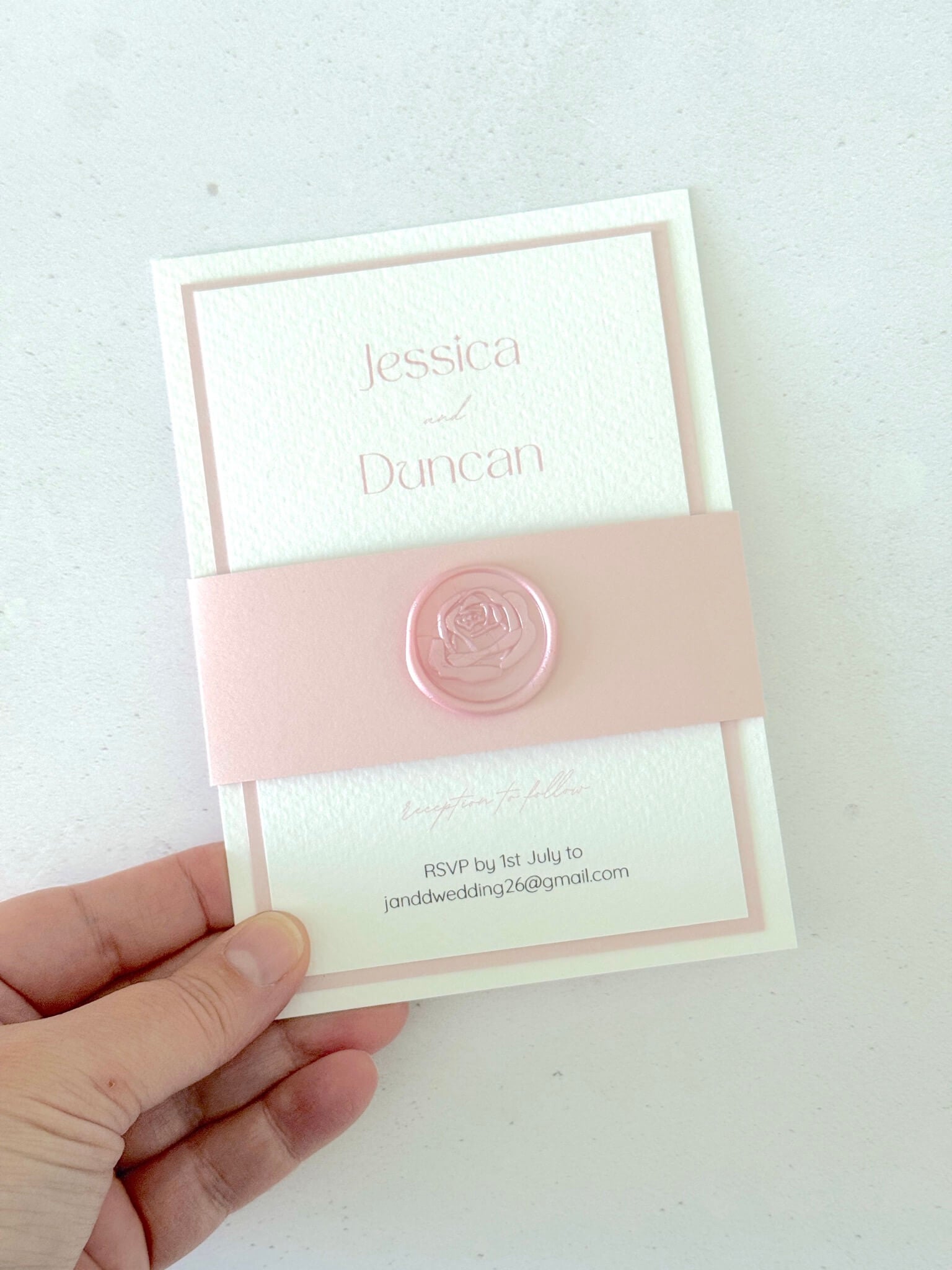 Pink handmade wedding invite with belly band and rose wax seal