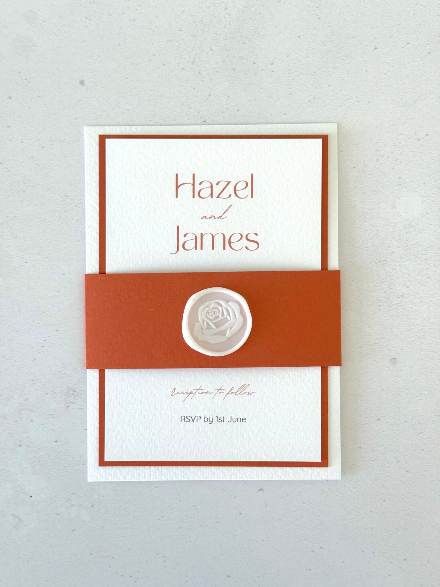 Lyn wedding invite with terracotta orange belly band and white wax seal