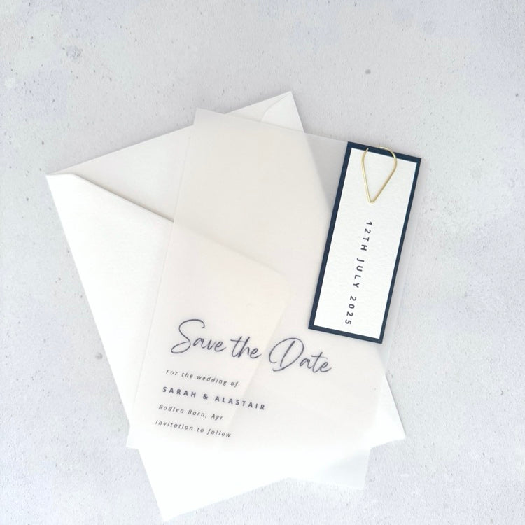 transparent vellum save the date card with navy date tag and gold teardrop paperclip