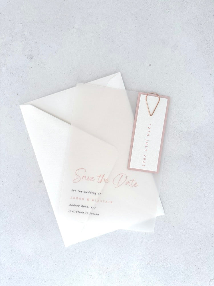 transparent vellum save the date card with blush pink date tag and teardrop paperclip