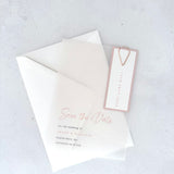 transparent vellum save the date card with blush pink date tag and teardrop paperclip