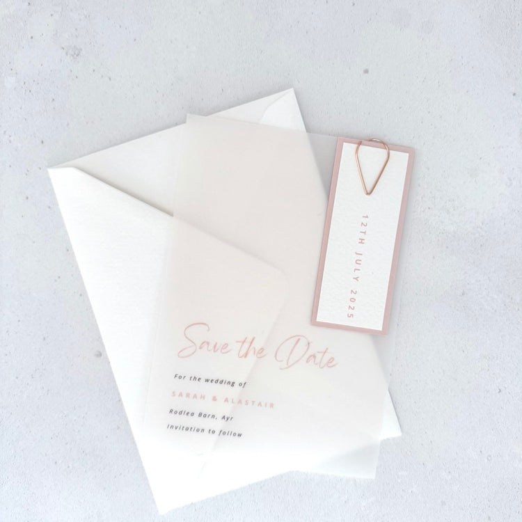 transparent vellum save the date card with blush pink date tag and teardrop paperclip