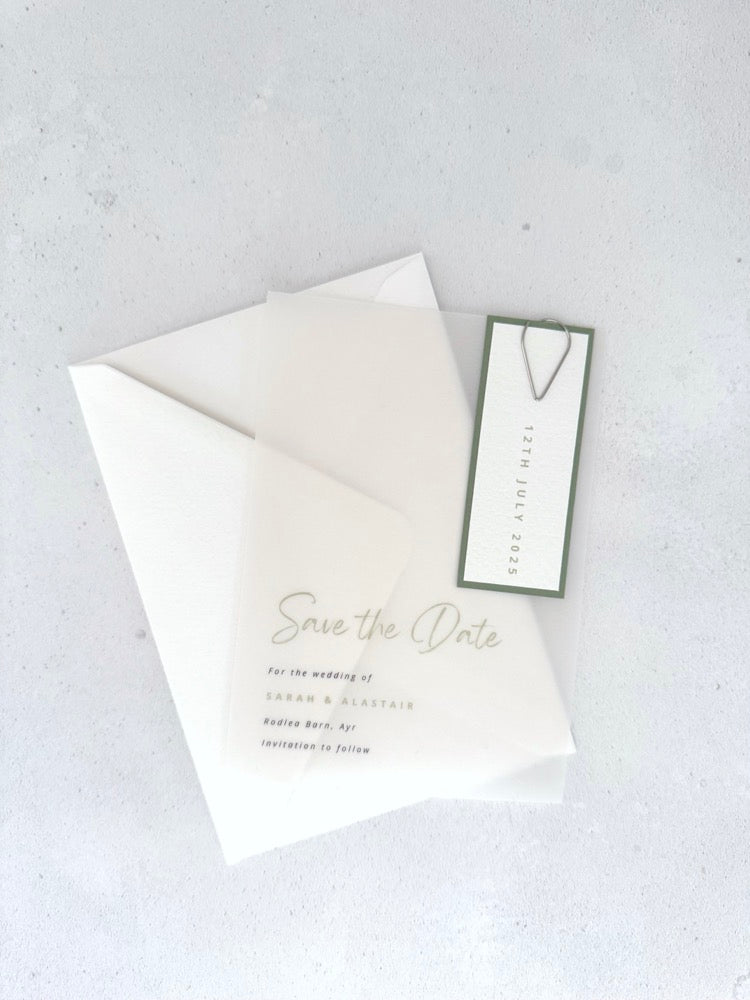 transparent vellum save the date card with sage green date tag and teardrop paperclip