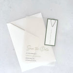 transparent vellum save the date card with sage green date tag and teardrop paperclip