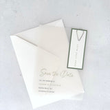 transparent vellum save the date card with sage green date tag and teardrop paperclip