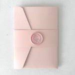 blush pink pocket wedding invite with pink belly band and handmade wax seal