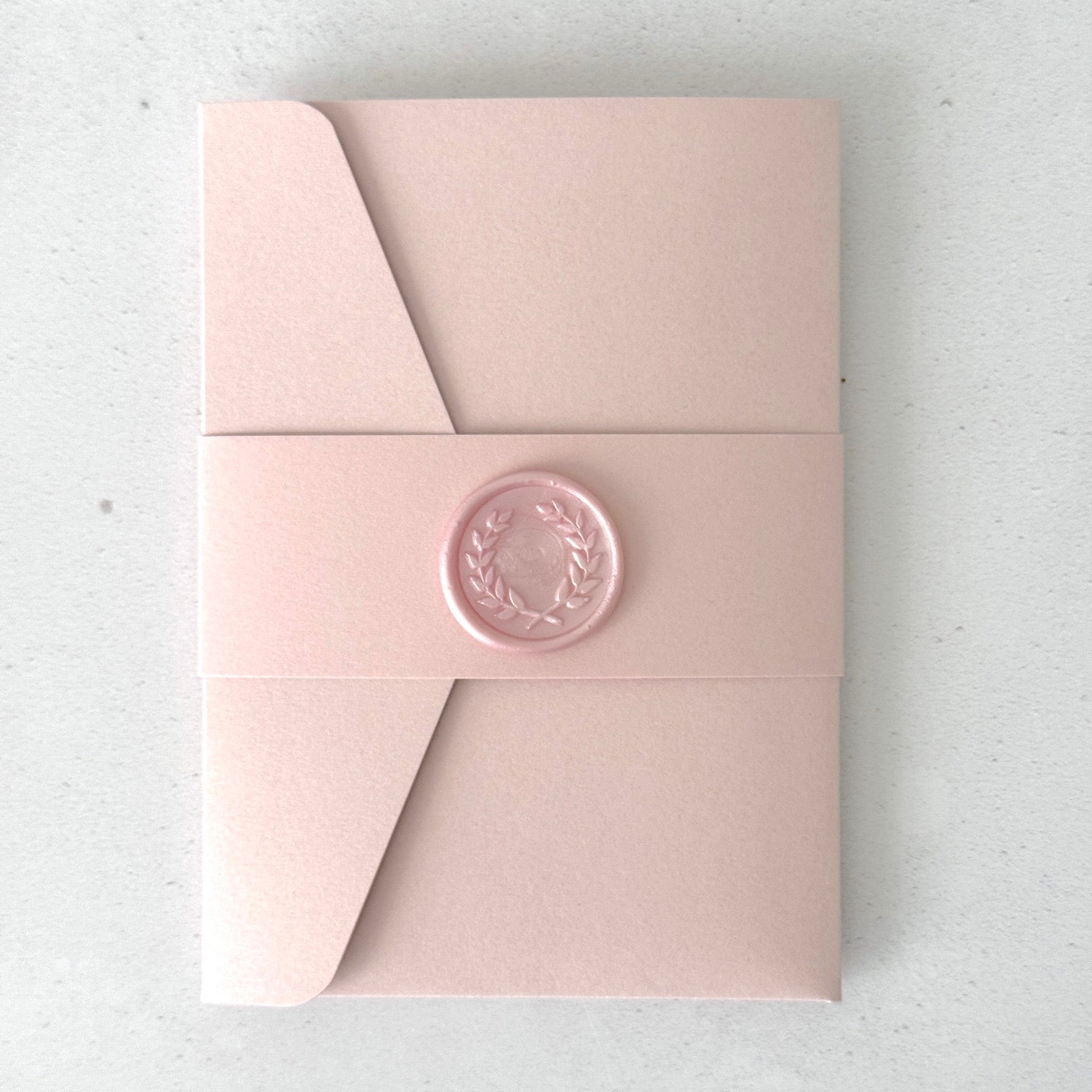 blush pink pocket wedding invite with pink belly band and handmade wax seal