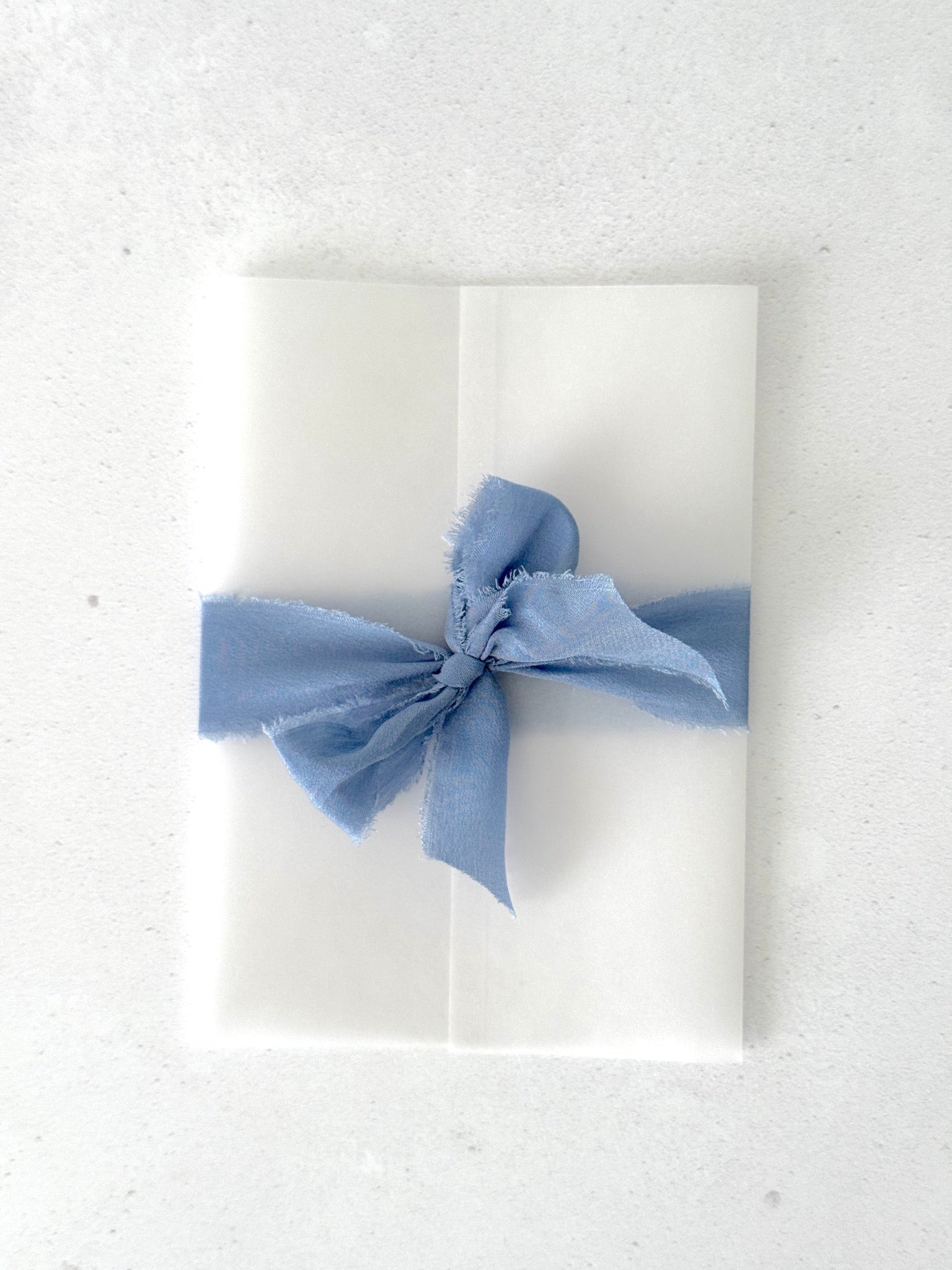 vellum wrap upgrade for wedding invites with tied ribbon