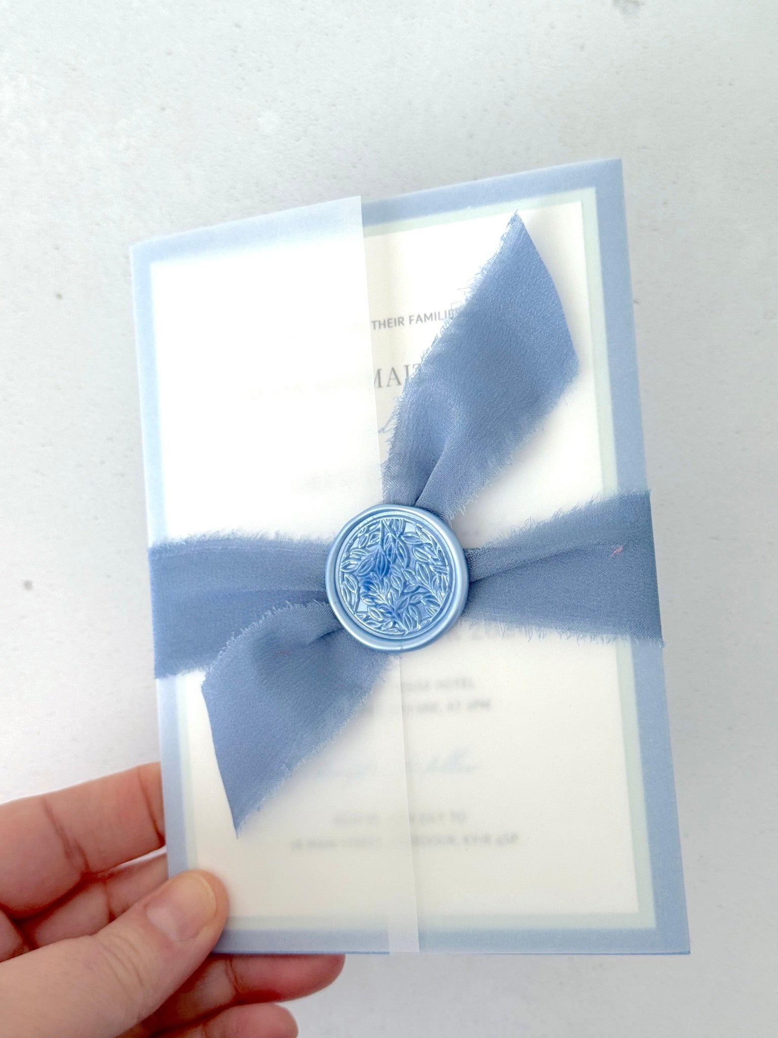 Jeni vellum jacket wrap wedding invite with cornflower blue tied silk ribbon handmade by zara