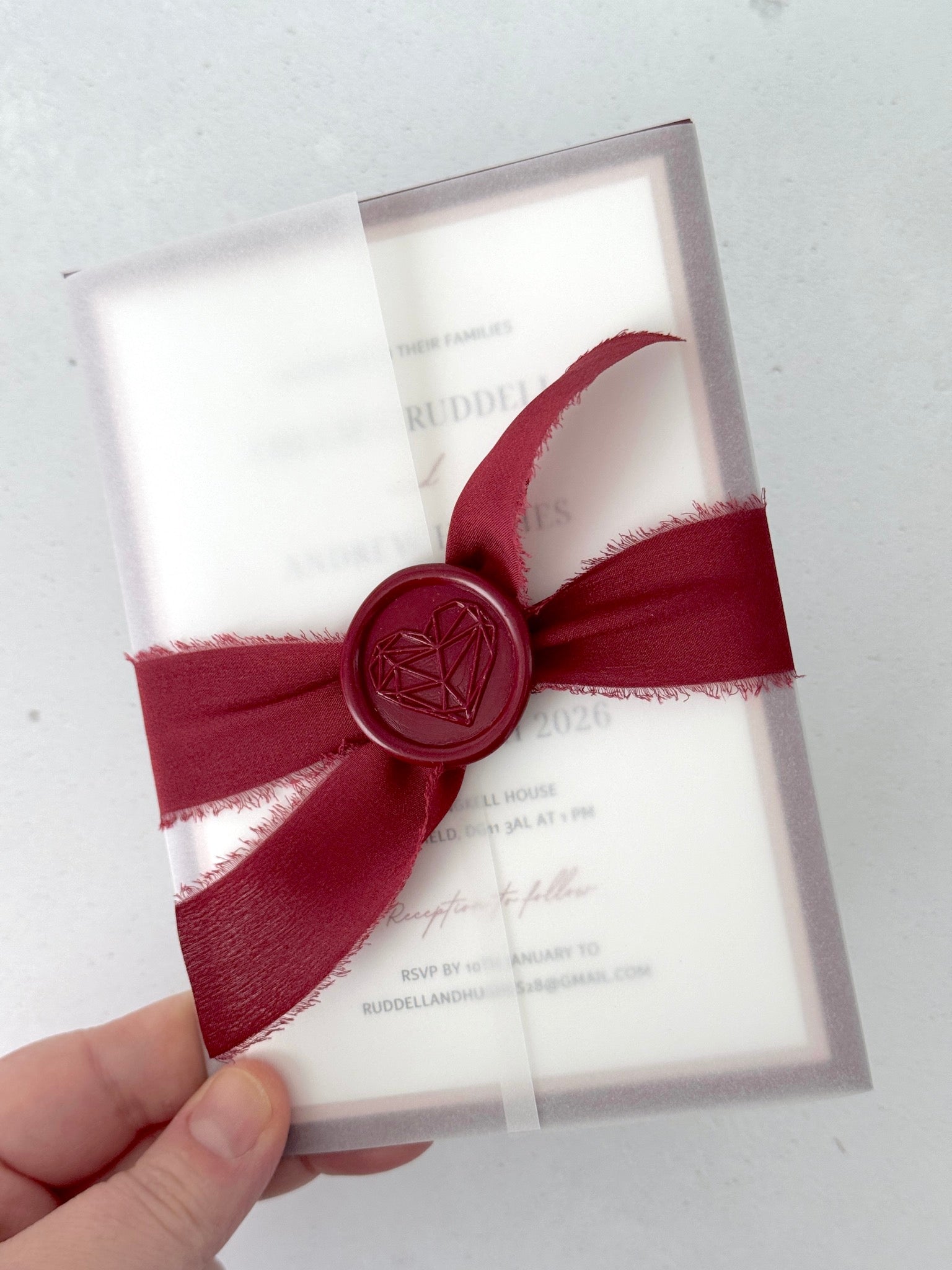 Jeni vellum sleeve wedding invite with burgundy tied silk ribbon and wax seal