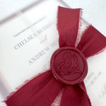 See through vellum paper wedding invite with silk burgundy tied ribbon