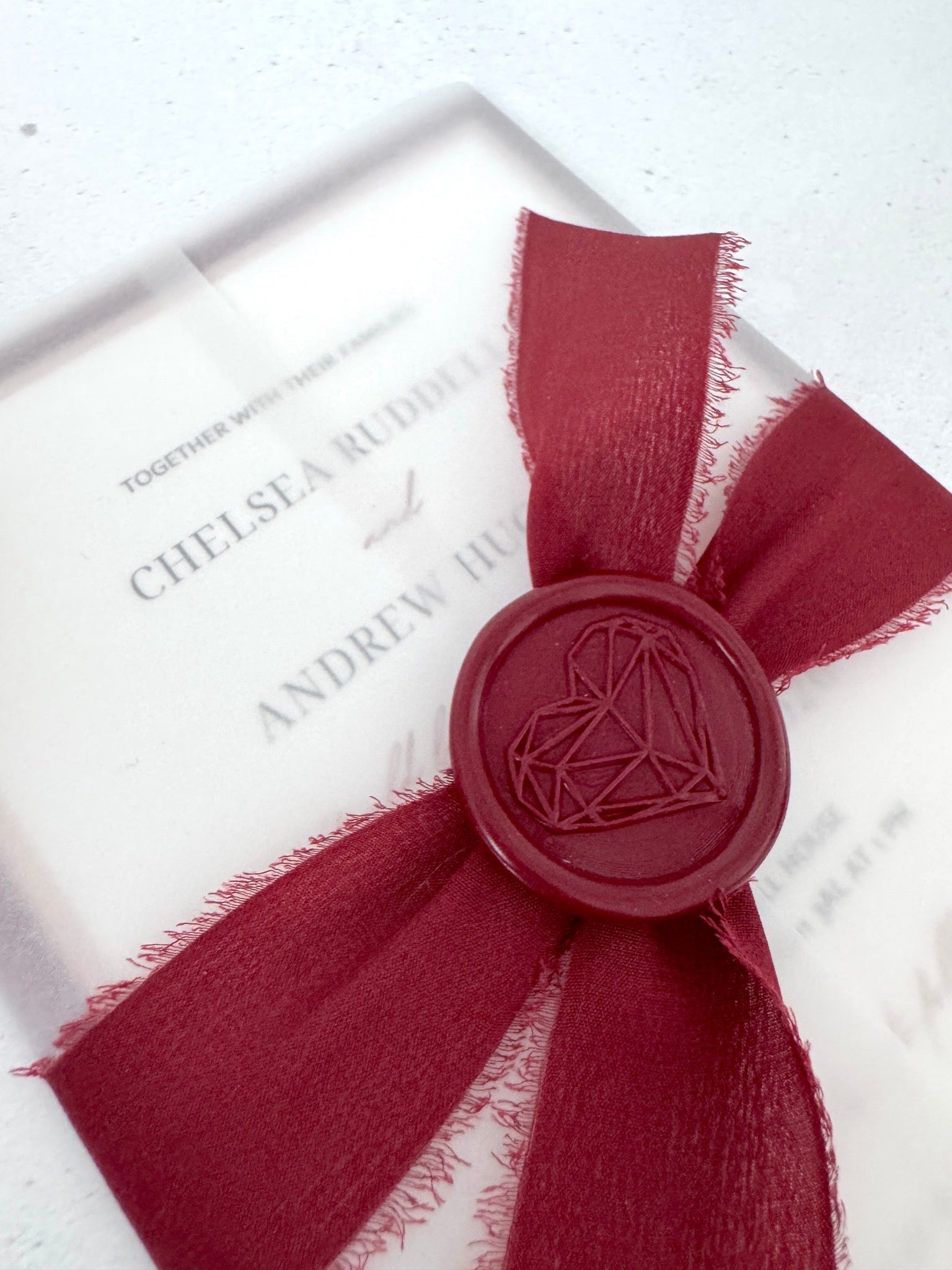 See through vellum paper wedding invite with silk burgundy tied ribbon