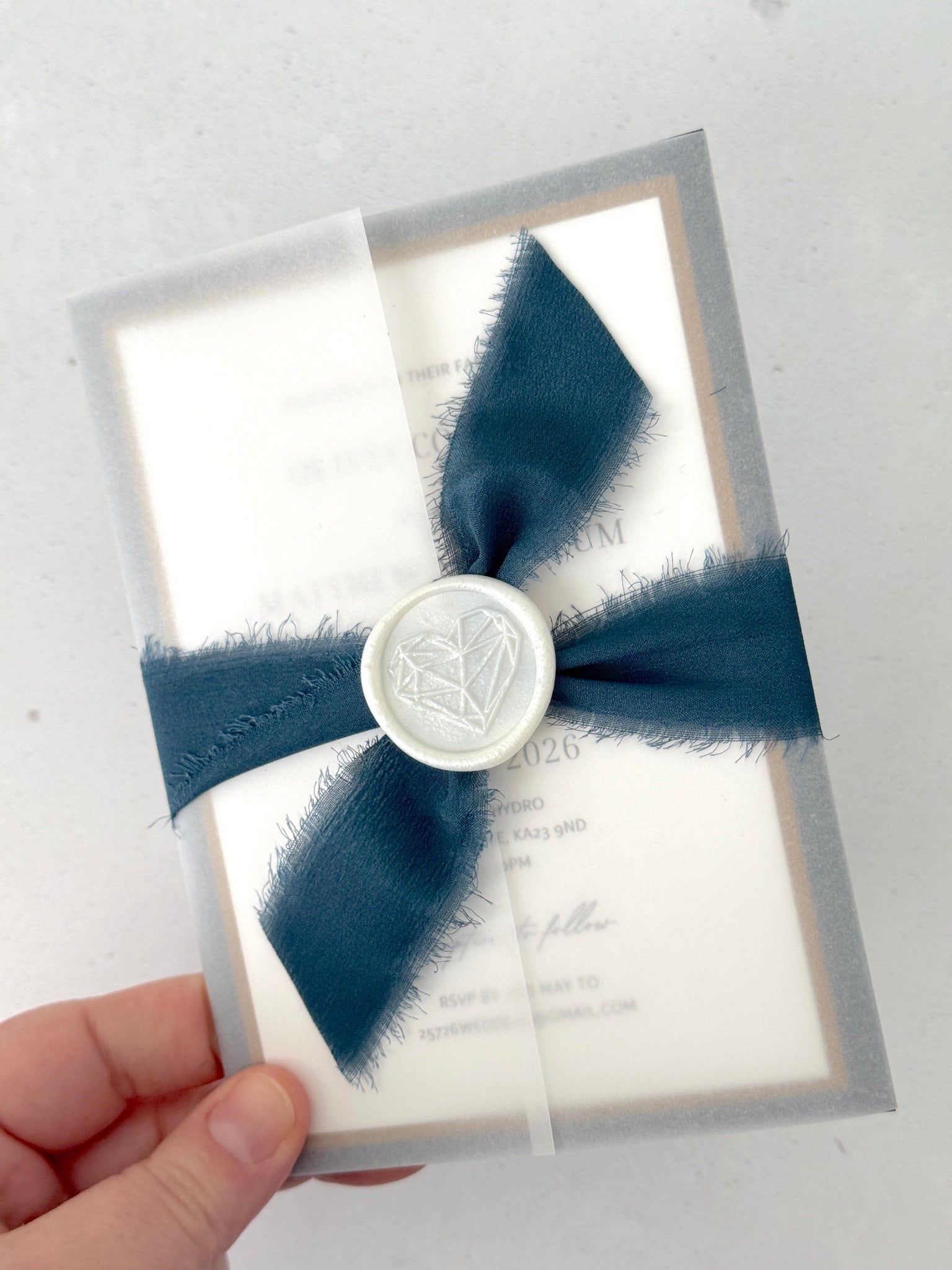 Jeni vellum jacket wrapped wedding invite with navy blue tied silk ribbon