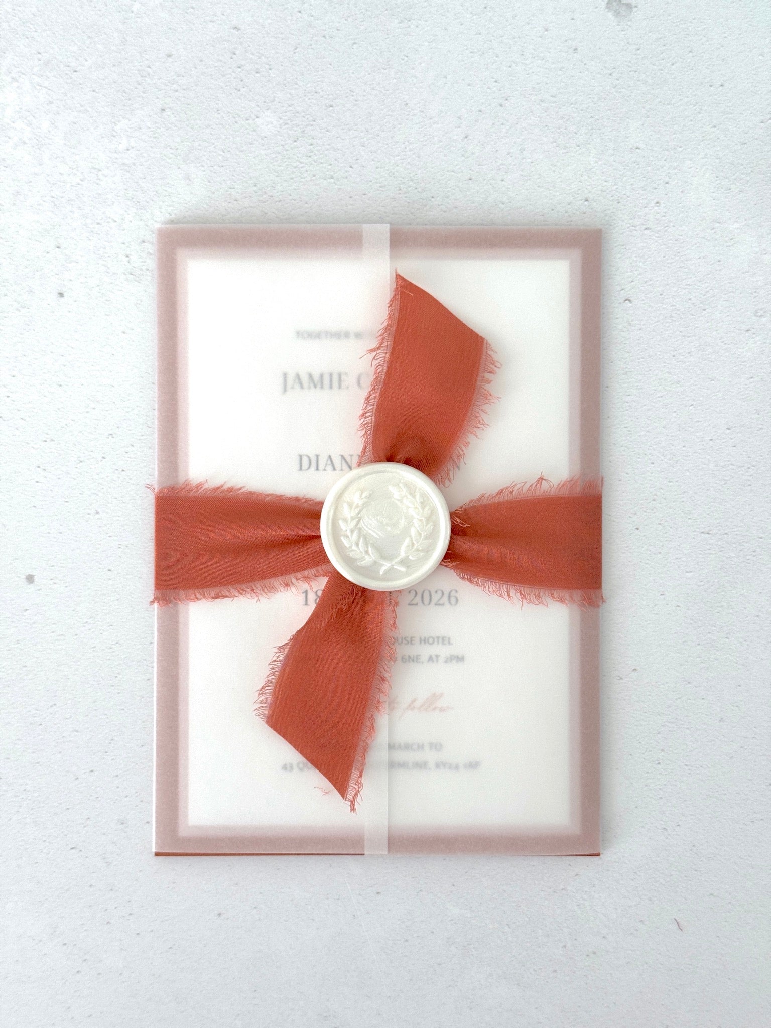 Transparent paper jacket wedding invite with tied silk ribbon