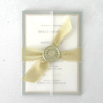 Handmade wedding invite with transparent vellum wrap, silk ribbon and wax seal closure