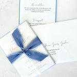 Jeni tied silk ribbon invite in dusky blue with info card and transparent vellum wrap handmade by zara dumfries