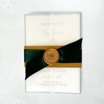 Vellum wrap invite with emerald green satin ribbon, belly band and custom gold wax seal