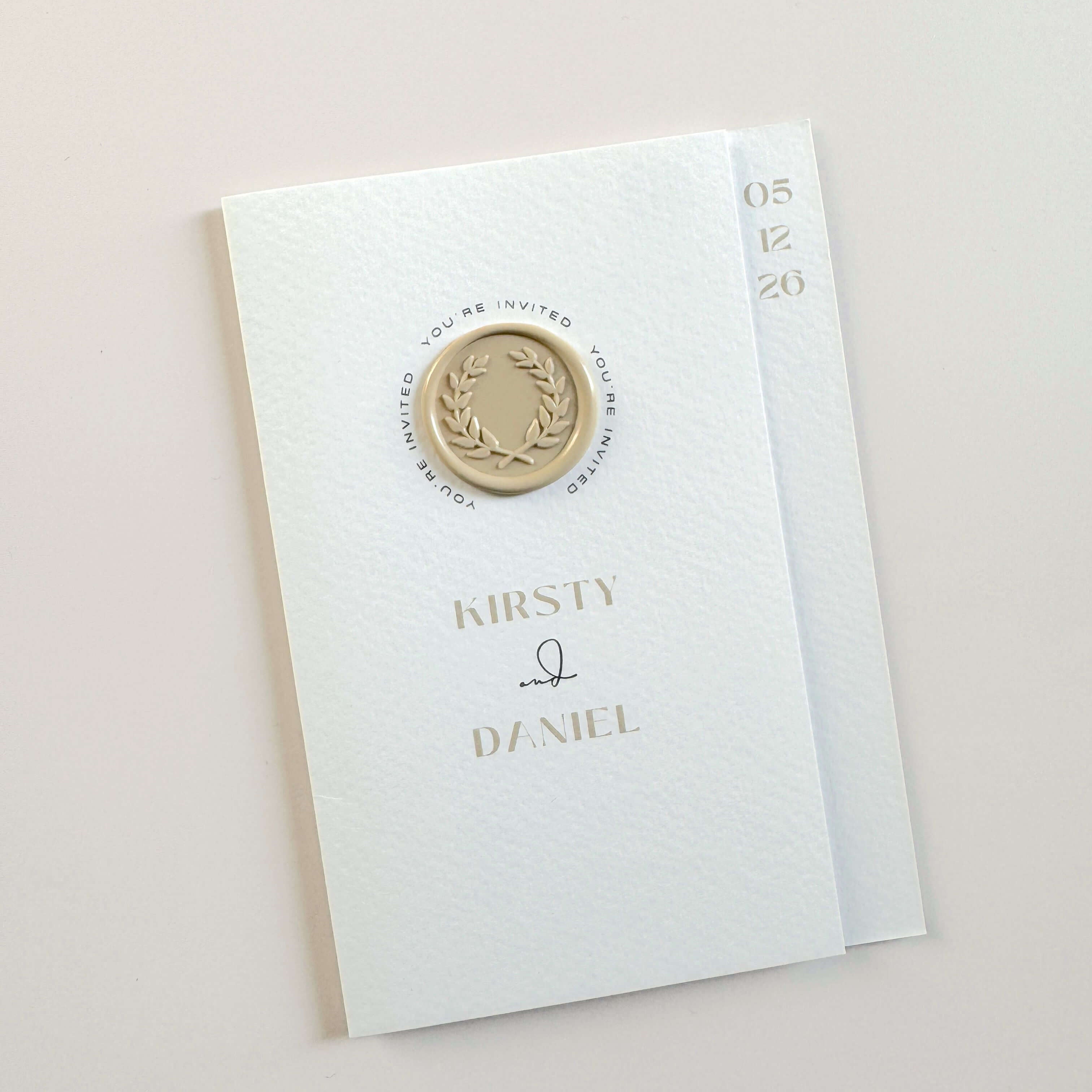 Kirsty folded wedding invite with neutral wreath wax seal