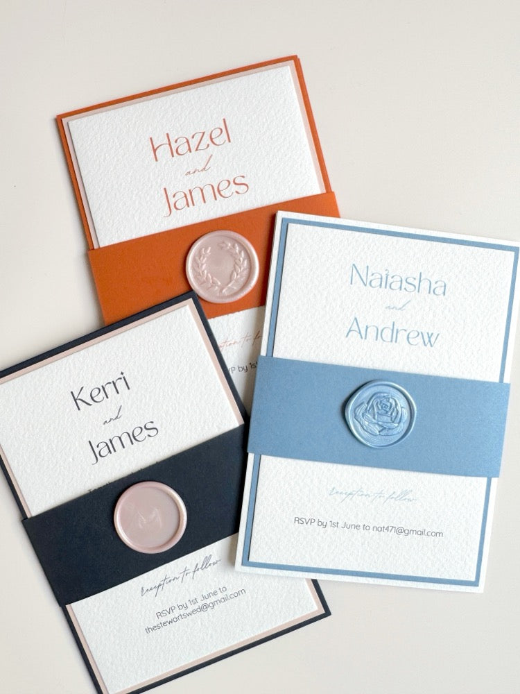 Group of lyn style belly band wedding invitations with handmade wax seals