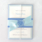 Wedding invite with dusty blue belly band and transparent paper wrap