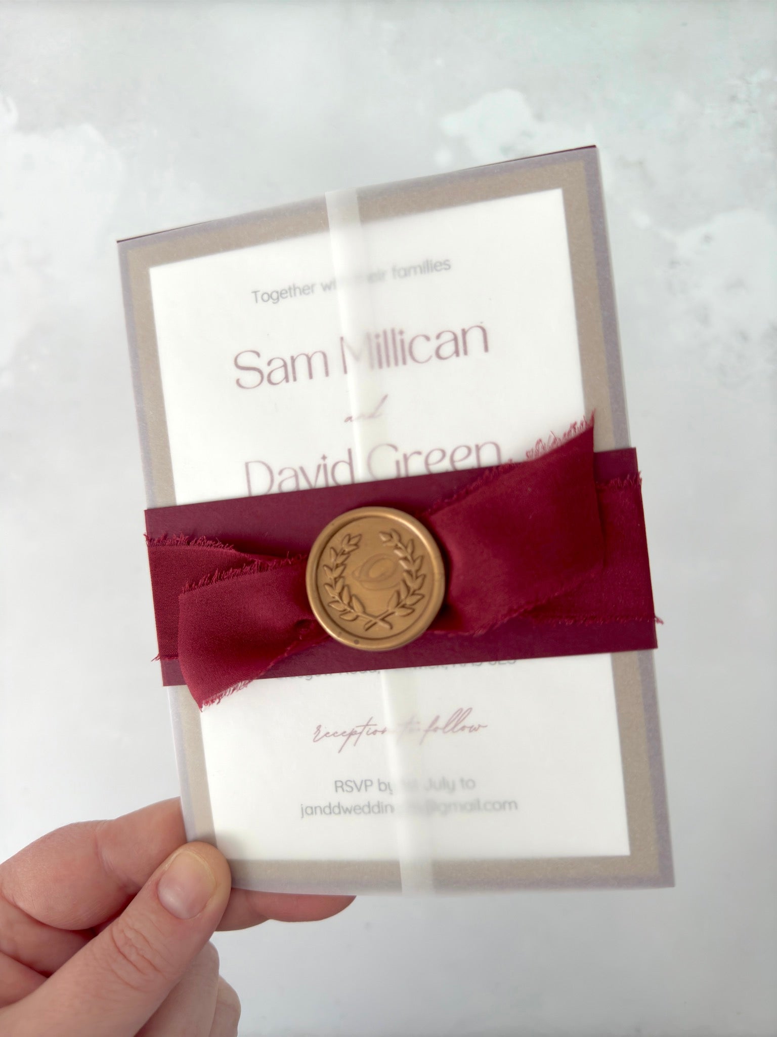 Lyn burgundy belly band and silk ribbon with gold wreath wax seal wedding invite in a vellum wrap