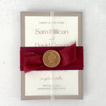 Postcard wedding invite in a transparent vellum jacket with burgundy belly band  and silk ribbon with a gold wax seal