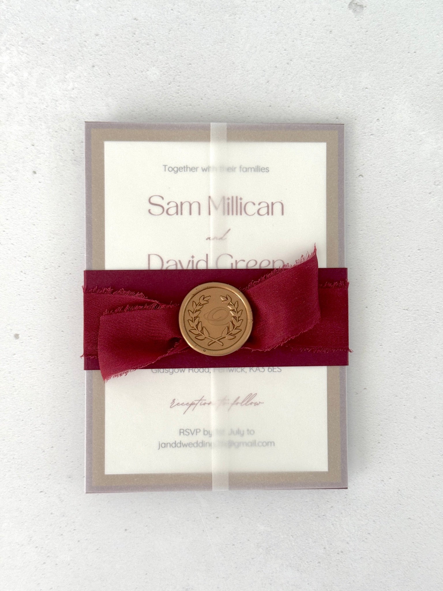 Postcard wedding invite in a transparent vellum jacket with burgundy belly band  and silk ribbon with a gold wax seal