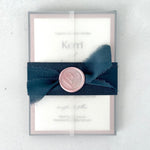 see thru paper wrapped wedding invite with navy belly band and pink wax seal