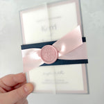 Navy and pink vellum jacket wedding invite with wax seal and belly band