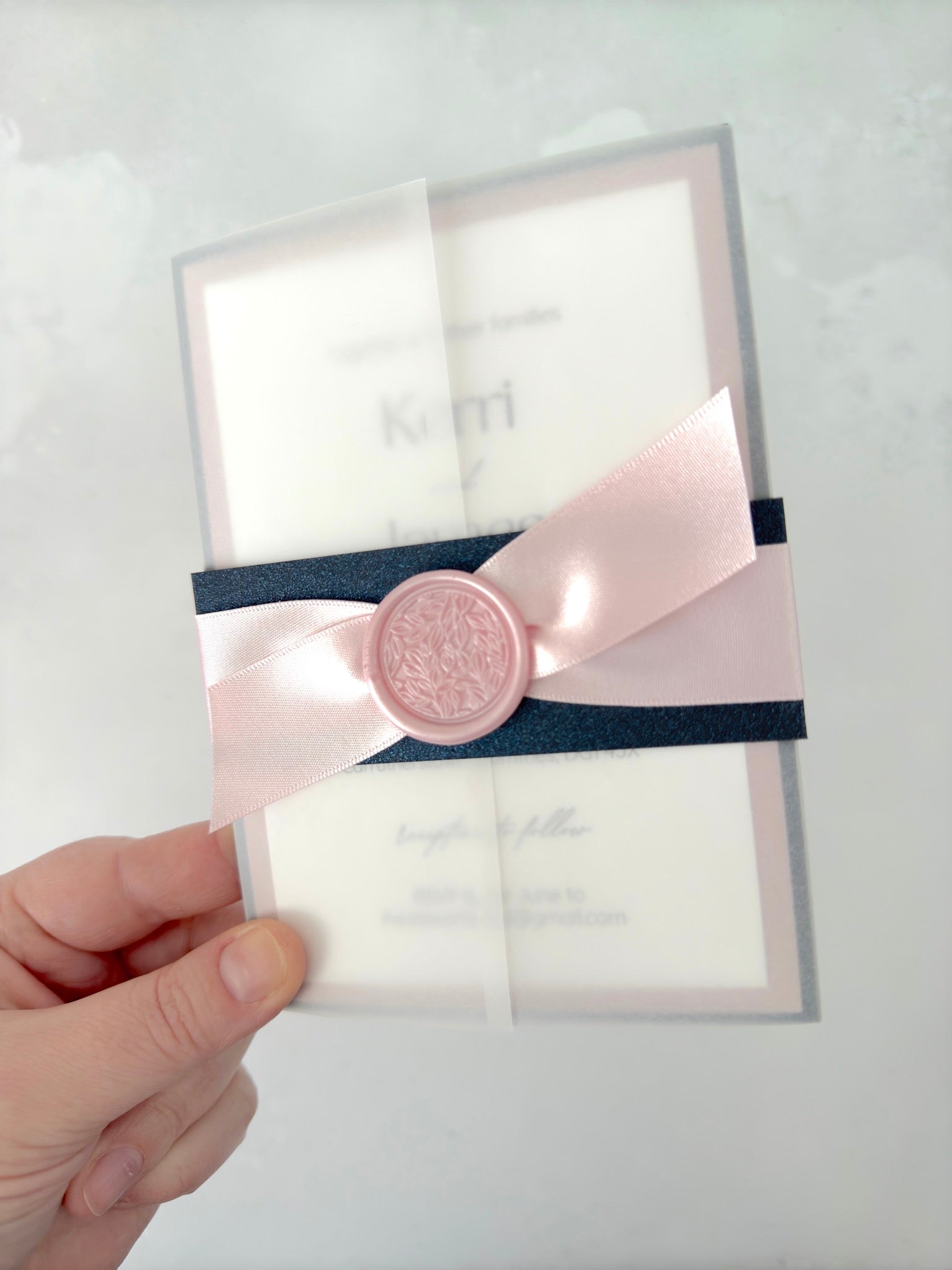 Navy and pink vellum jacket wedding invite with wax seal and belly band