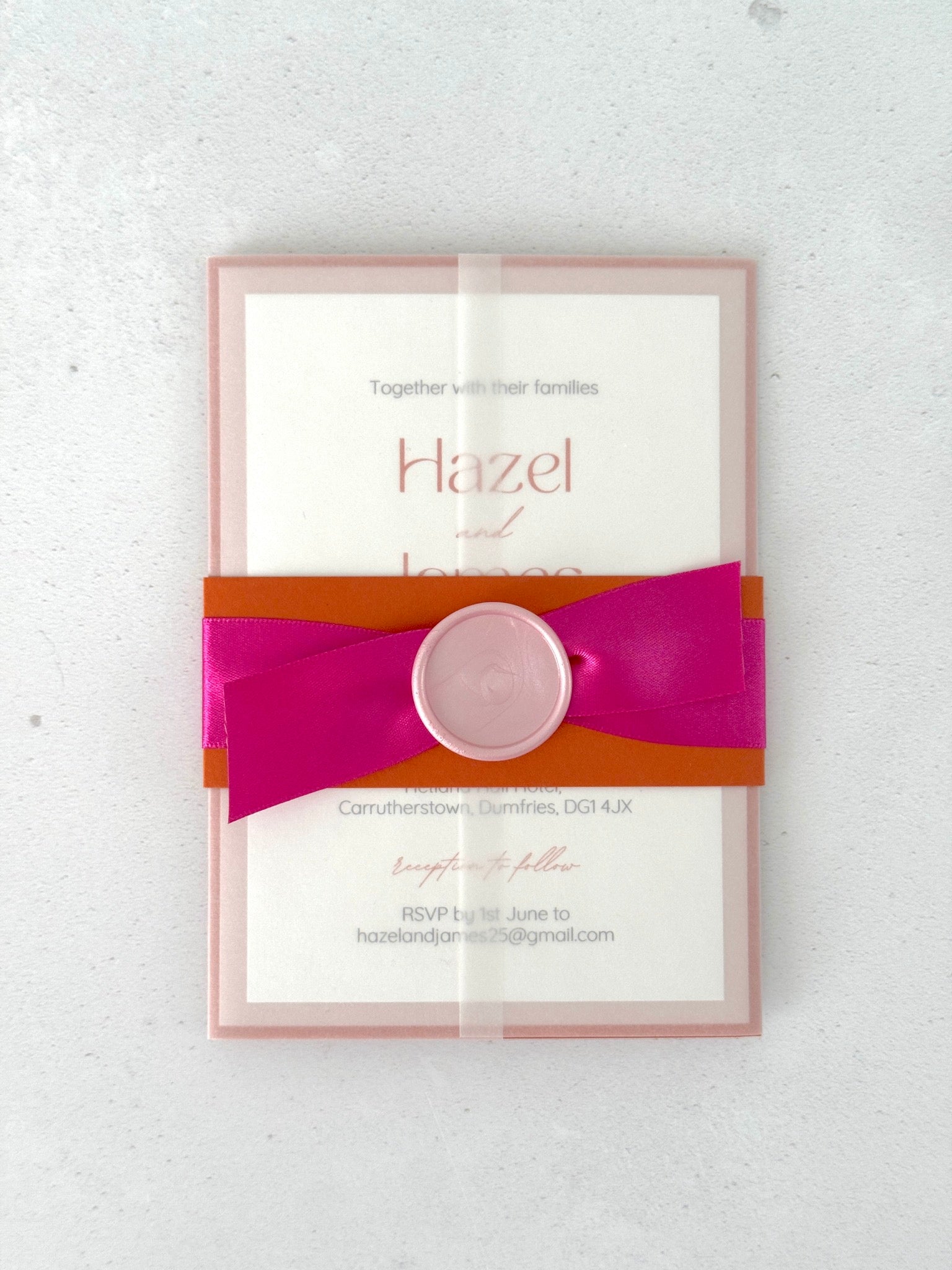 transparent paper wrap wedding invitation with pink and orange belly band