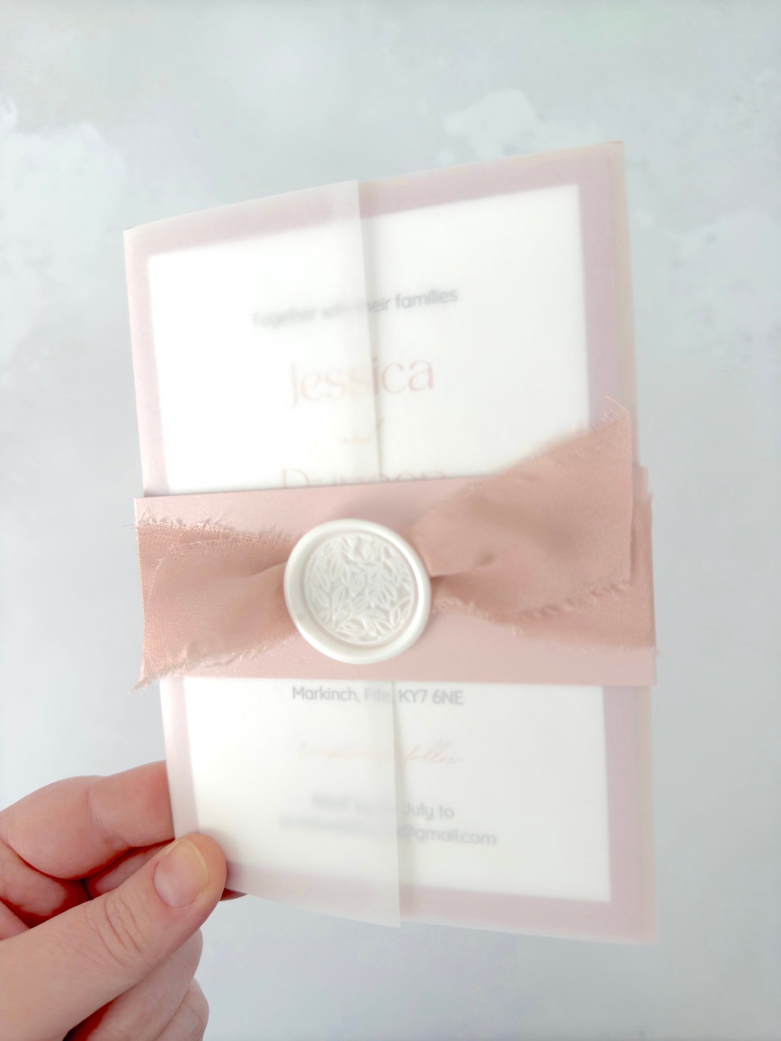 Vellum wedding invitation with belly band and silk ribbon, with white wax seal