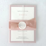 Pink wedding invite with see thru paper and belly band with wax seal