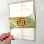 Lyn vellum sleeve wedding invitation with gold belly band wax seal and sage green satin ribbon